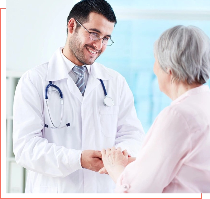 A doctor is shaking hands with an older woman.