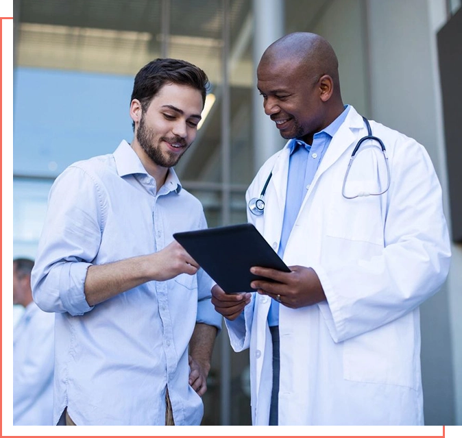 Two doctors are looking at a tablet.