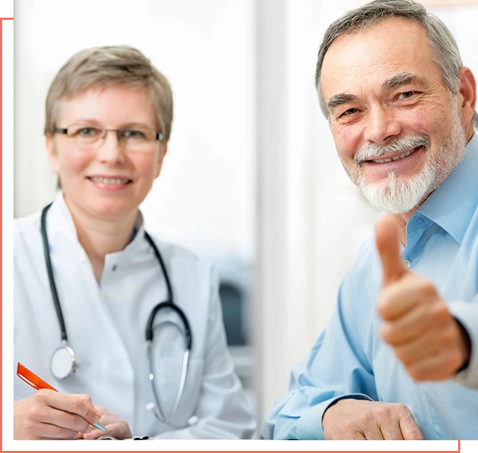 A man and woman sitting at a table with thumbs up.